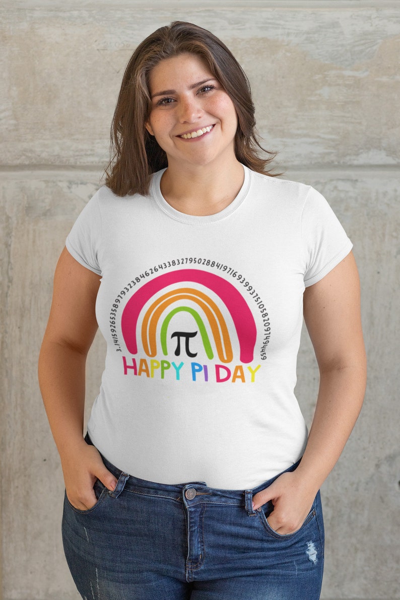 May include: White t-shirt featuring a rainbow design with the pi symbol and numbers, and the text "Happy Pi Day." The shirt is worn by a person with brown hair and blue jeans.