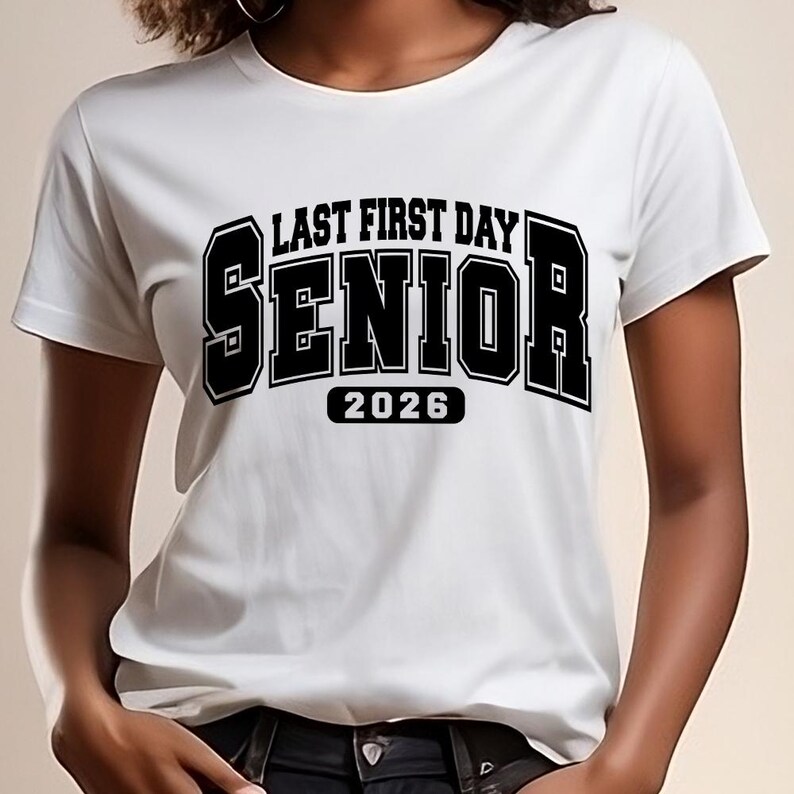 May include: White t-shirt featuring the text "LAST FIRST DAY SENIOR 2026" in a bold, black font. The shirt has short sleeves and is likely made of a soft fabric. The design is in a collegiate style.
