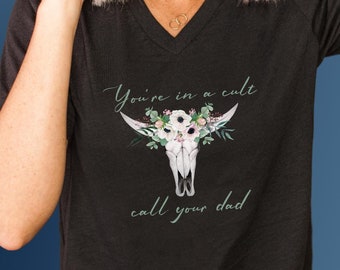 May include: Black V-neck t-shirt with a floral skull graphic and the text "You're in a cult call your dad".