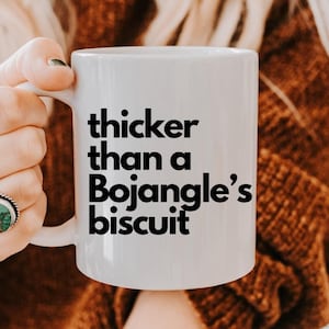 May include: White ceramic mug with black text that reads "thicker than a Bojangles' biscuit".