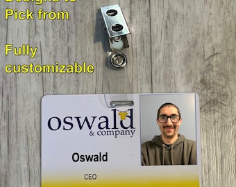May include: A white plastic ID card with a yellow border. The card has a blue logo that says "oswald & company" and a photo of a person wearing a grey hoodie. The text "Oswald CEO" is printed below the photo.