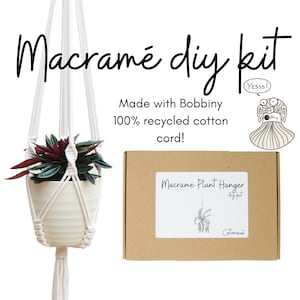 May include: A DIY macrame plant hanger kit made with 100% recycled cotton cord. The kit includes instructions and all the materials needed to create a macrame plant hanger. The kit is packaged in a brown box with a white label that says "Macrame Plant Hanger diy kit Cotonou".