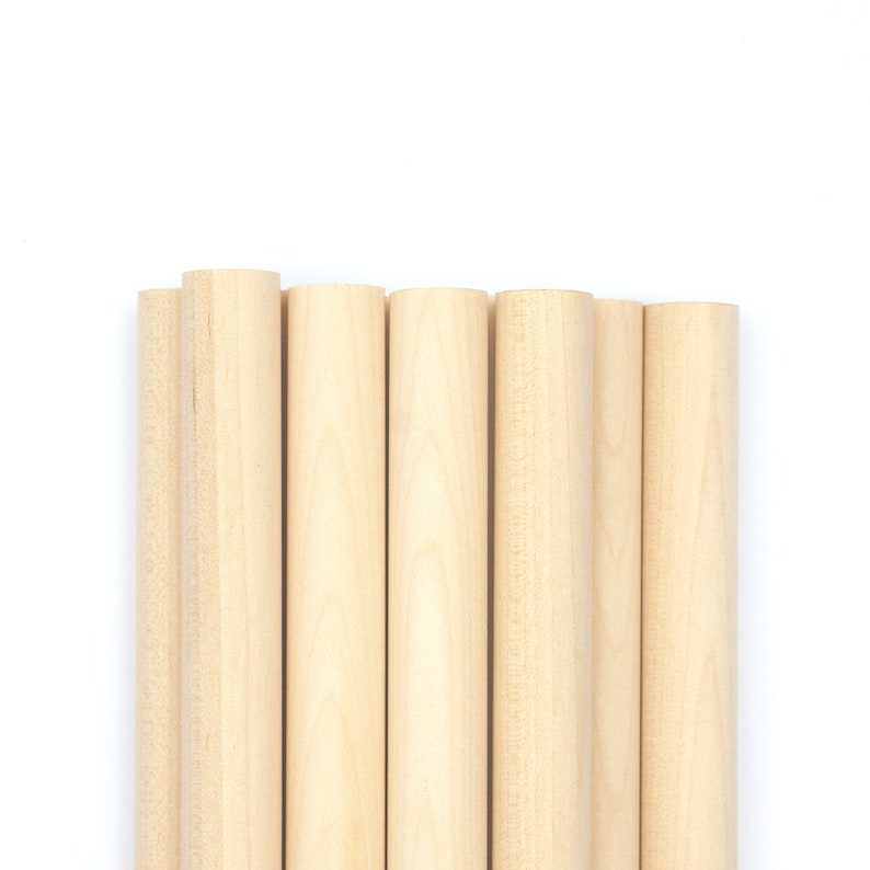 Puede incluir: Un conjunto de siete clavijas de madera, todas del mismo tama&ntilde;o y color, dispuestas en fila. Las clavijas son de color marr&oacute;n claro y tienen un acabado liso y pulido.