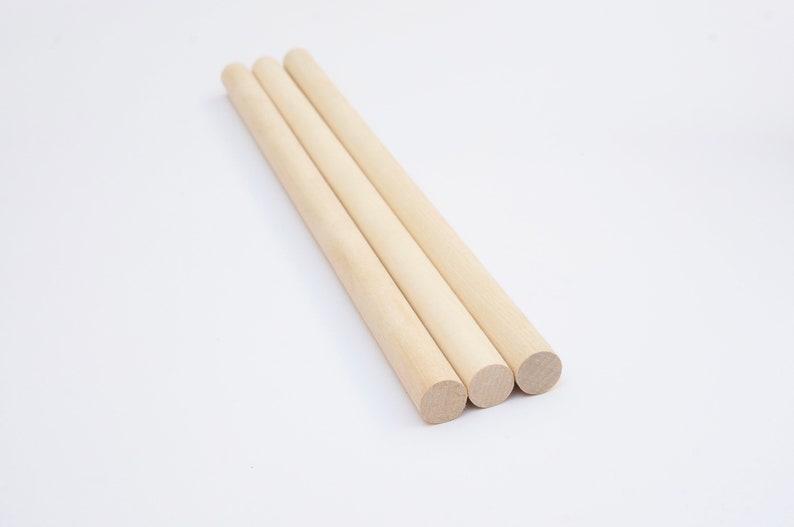 Puede incluir: Tres tacos de madera natural, cada uno de aproximadamente 30 cm de largo, con extremos redondeados. Los tacos est&aacute;n dispuestos en una fila, con los extremos ligeramente superpuestos.