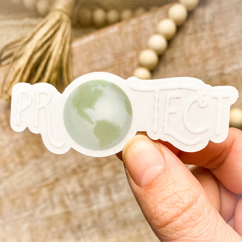 May include: White sticker with the word "PROTECT" in a stylized font. A green globe with continents is centered in the sticker.