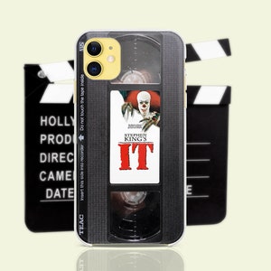 May include: A black and silver iPhone case with a vintage VHS tape design. The case features a red and white "IT" movie poster with the text "Stephen King's IT".