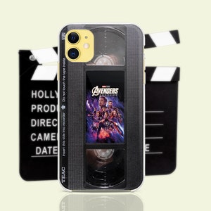 May include: A black and silver phone case with a vintage VHS tape design. The case features a clear window showing the Avengers Endgame movie poster. The text "AVENGERS ENDGAME" is visible on the case.