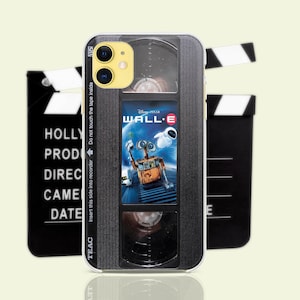 May include: A black and silver phone case with a vintage VHS tape design. The case features a still from the movie WALL-E, with the text "Disney Pixar WALL-E" on the front. The case has a black and silver design with a silver trim around the edges.