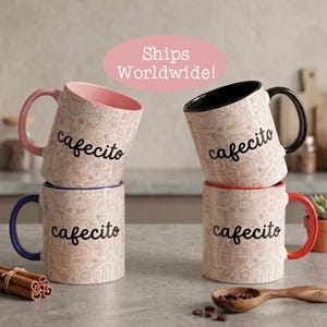 May include: Four ceramic mugs with a light beige background featuring a repeating brown line art pattern of coffee-related items and the word cafecito in black script. The mugs have contrasting colored handles and interiors in pink, black, blue, and red.