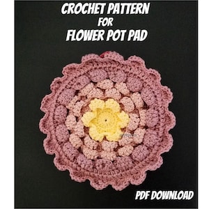 May include: Crochet pattern for a flower pot pad. The pad is a round, multi-coloured crocheted design with a yellow centre and pink and red outer layers. The pattern is available as a PDF download.
