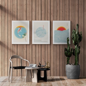 May include: Three framed prints with Japanese-inspired designs. The left print features a red and white fish swimming in a blue circle. The middle print features a blue and white wave pattern in a circle. The right print features a blue and white wave pattern with a red sun.