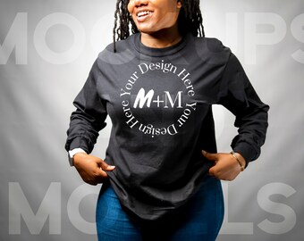 Op de afbeelding: Een zwart longsleeve shirt met een wit cirkelvormig ontwerp met de tekst "Design Your Here Your Design Here" en "M+M" in het midden.