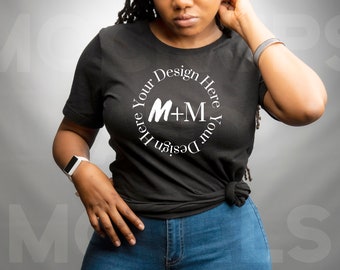 May include: A black t-shirt with a white circle design that says "Design Your Here Here Your Design" with the letters M+M in the center.