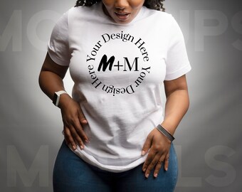 May include: White t-shirt with a circular design that reads "Your Design Here" around the letters "M+M". The model is wearing blue jeans and a white watch. A silver bracelet is on the model's wrist.