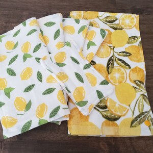 May include: Set of five white kitchen towels with a lemon print. The towels are made of a soft, absorbent material and are perfect for drying dishes, hands, and spills.
