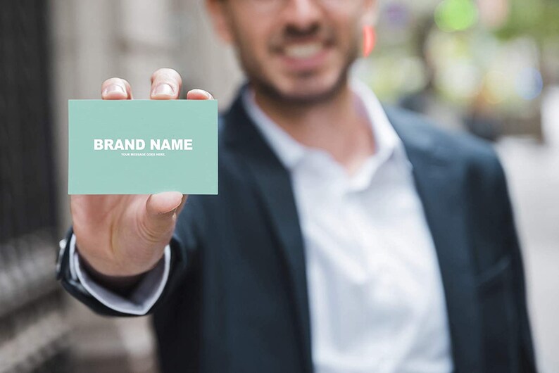 May include: A person holding a light blue business card with the text "BRAND NAME" and the words "YOUR MESSAGE GOES HERE".