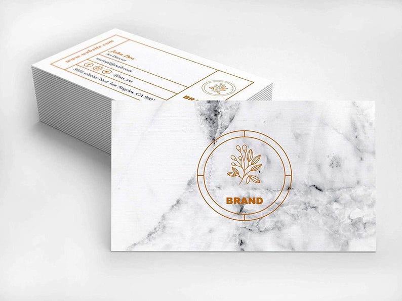 May include: A white marble business card with a gold circle containing a line drawing of a branch with leaves and the word "BRAND".