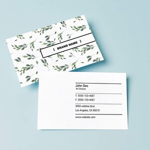 May include: A white business card with a green leafy pattern and the text "[BRAND NAME]" on the top. The bottom of the card has the name "John Deo", the title "Art Director", a phone number, a fax number, an address, and a website address.