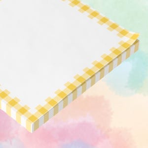 May include: A pad of white notepaper with a yellow and white gingham border. The paper is angled, revealing the edge of the pad. The background is a watercolour wash of pastel colours.