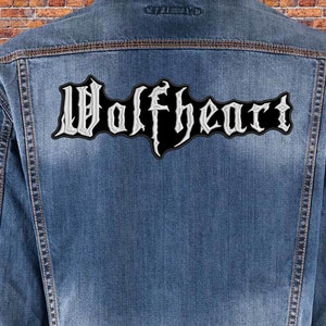 May include: A denim jacket with a black and white embroidered patch that says "Wolfheart" on the back.