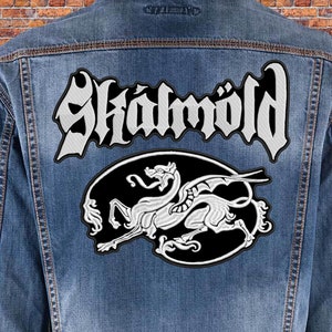 May include: A denim jacket with a white embroidered patch featuring the band name "Skalmöld" and a black and white dragon design.