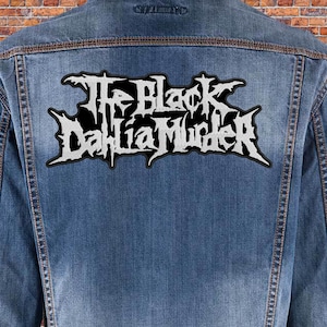 Op de afbeelding: Een spijkerjack met een witte geborduurde patch met de tekst "The Black Dahlia Murder" op de achterkant.