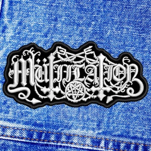Può includere: Toppa ricamata bianca con la parola "MUTILATION" in carattere gotico su sfondo nero. La toppa è su un tessuto di jeans blu.