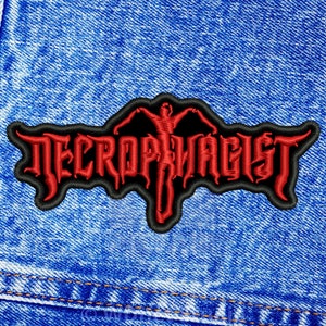May include: Red embroidered patch with the text "NECROPHAGIST" in a black gothic font. A red figure with outstretched arms is in the centre of the patch.