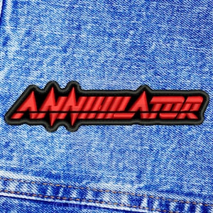 May include: Red and black embroidered patch with the word "Annihilator" on a blue denim background.