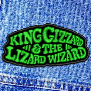 May include: Green and black embroidered patch with the text "King Gizzard & The Lizard Wizard" on a blue denim background.