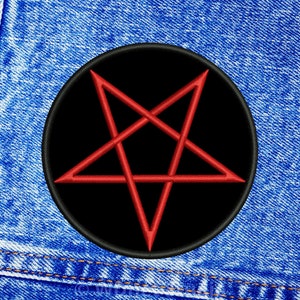 Könnte beinhalten: Ein schwarzer runder Patch mit einem roten Pentagramm, der auf einen blauen Jeansstoff genäht ist.