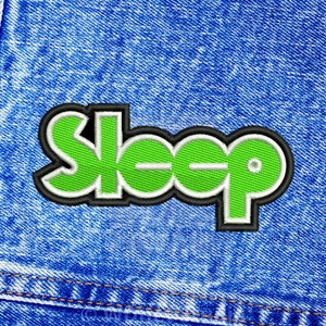 Peut inclure: Écusson brodé avec le mot "Sleep" en vert vif, souligné de blanc et de noir. Le patch est cousu sur un tissu denim bleu, avec des détails de couture visibles. Un accessoire amusant pour vêtements ou sacs.