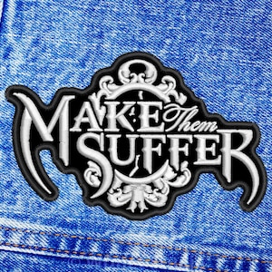May include: A black and white embroidered patch with the text "Make Them Suffer" in a stylised font. The patch features a clock face design with ornate details.