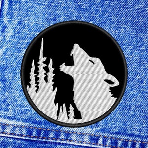 May include: A black and white embroidered patch of a wolf howling at the moon. The wolf is white and the background is black. The patch is circular and has a black border.