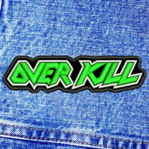May include: Embroidered patch with the words "OVER KILL" in bright green, outlined in white and black. The patch is rectangular and set against a blue denim background, with visible stitching.