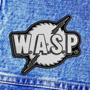 May include: A black and white embroidered patch with the word "WASP" in a bold font. The patch features a lightning bolt and a circular design with a sawtooth edge.