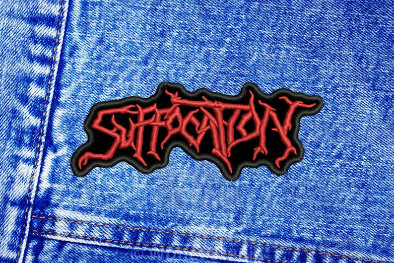 K&ouml;nnte beinhalten: Roter gestickter "Suffocation" Band-Patch auf blauem Jeansstoff.