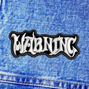 May include: A black and white embroidered patch with the word "WARNING" in a stylized font.