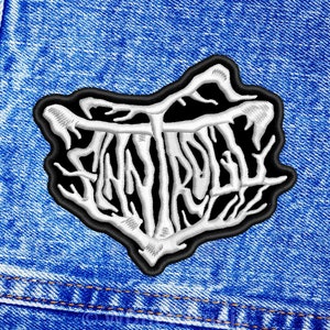 May include: White embroidered patch with the word "Entrails" in a gothic font on a black background. The patch is sewn onto a blue denim jacket.