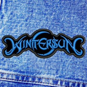 Può includere: Una toppa ricamata blu e nera con il testo "Wintersun" su uno sfondo in denim.