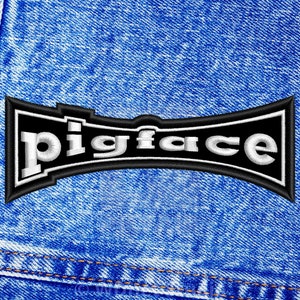 May include: A black and white embroidered patch with the word "pigface" in white lettering on a black background. The patch is sewn onto a blue denim jacket.
