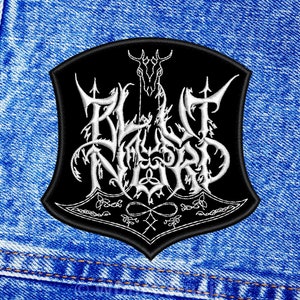 May include: Black and white embroidered patch with the text "BLUT AUS NORD" in a stylized font. The patch features a skull with antlers and other decorative elements.