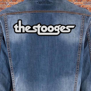 May include: A denim jacket with a white and black "The Stooges" patch on the back.