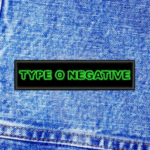 May include: A black patch with white stitching and the words "TYPE O NEGATIVE" in green letters on a blue denim background.