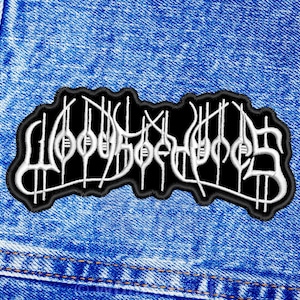 Puede incluir: Parche blanco bordado sobre fondo negro con la palabra "WOO DOO" en una fuente estilizada.