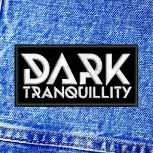 Op de afbeelding: Een zwarte patch met witte tekst die "DARK TRANQUILLITY" zegt op een blauwe denim achtergrond.