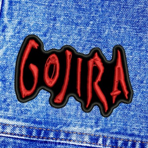Könnte beinhalten: Roter gestickter "GOJIRA"-Patch auf blauem Jeansstoff.