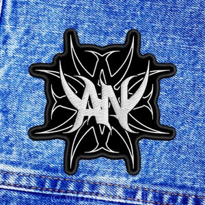 Pode incluir: Etiqueta bordada preta e branca com um logotipo "YAN" estilizado em um design tribal.