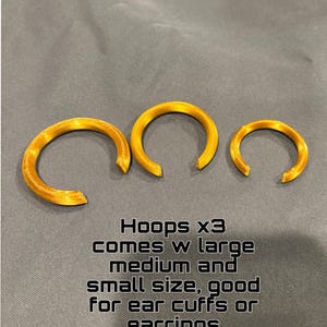 Może przedstawiać: Trzy złote koliste obręcze w r&oacute;żnych rozmiarach, w tym duży, średni i mały. Tekst na obrazku brzmi: Hoops x3 comes w large medium and small size, good for ear cuffs or earrings. Każda obręcz posiada otw&oacute;r w kształcie litery C.