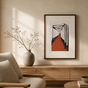 May include: A framed wall art print featuring a black and white ink-style illustration of a path lined with vertical pillars leading toward a bright opening, set against a textured terracotta-colored ground, displayed in a dark brown frame.